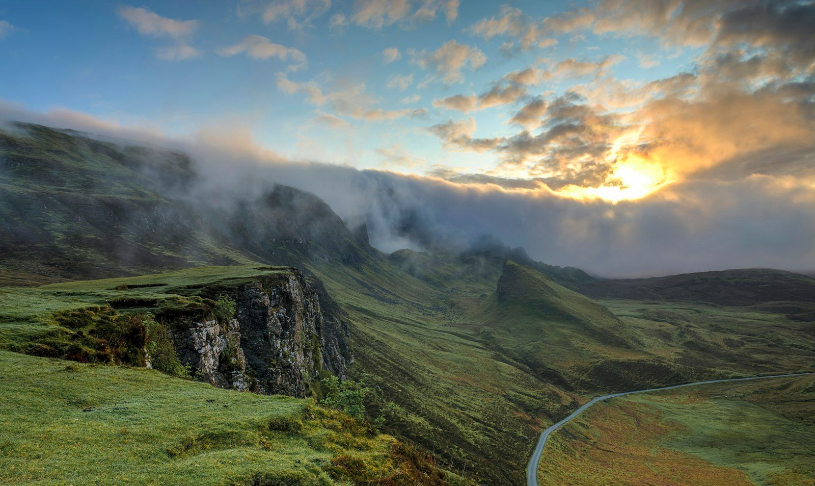 Winding road through green misty hills
